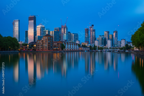 London cityscape Canary Wharf with reflection from Greenland Dock during twilight
