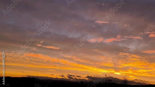 golden sunrise with clouds creating dramatic sky over landscape