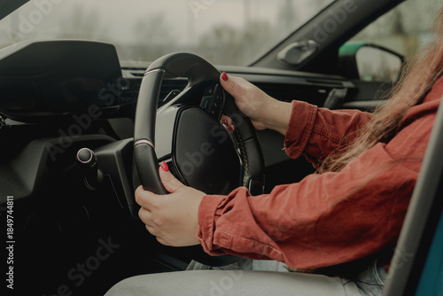 Female hands on steering wheel in modern car interior, calm driving concept