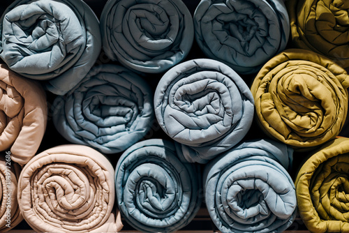 Folded weighted sensory blankets neatly stacked, soft textile texture.