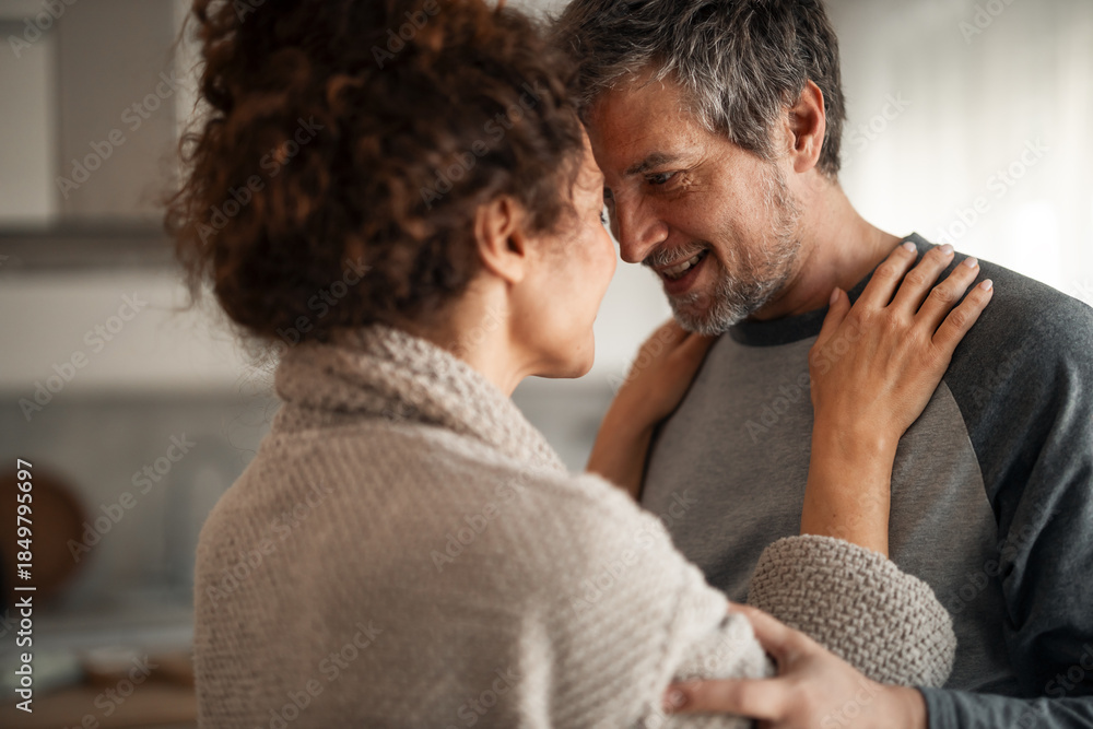 Fototapeta premium Warm Embrace Between Couple in Cozy Home Kitchen Sharing Happiness, Love, and Connection