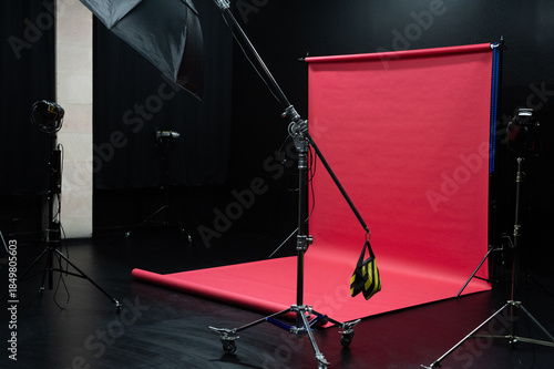 Photo studio interior with black cyclorama and red background.