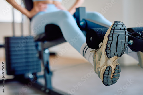 Foto Woman focusing on leg extension exercise at the gym, building strength and tonin