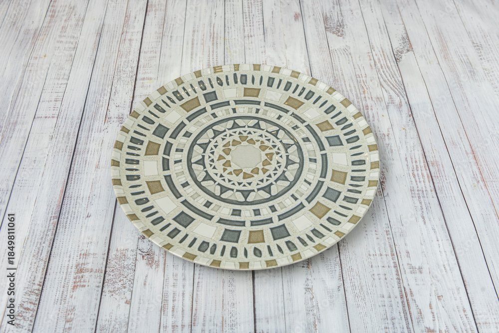 Obraz premium A polychrome porcelain plate on a white table