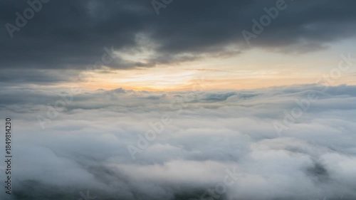 Breathtaking drone hyperlapse of a dense sea of clouds flowing over mountain peaks at sunrise. This cinematic aerial footage captures the ethereal beauty of morning mist and golden sunlight.