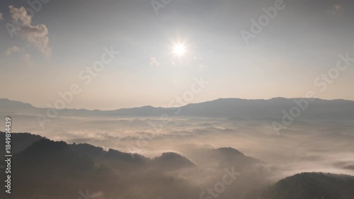Hyperlapse by drone Spectacular aerial view of a sea of mist covering mountain ranges under a bright morning sun. Captures peaceful nature, morning fog, and scenic horizons at sunrise.