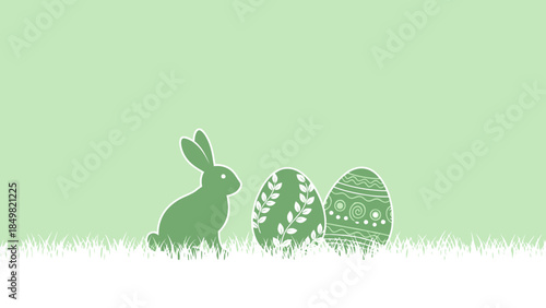 Easter bunny and two decorated eggs on grass