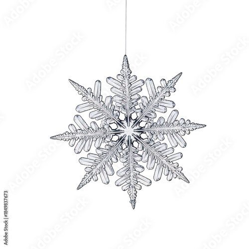Extreme close up macro photograph of a perfect six sided ice crystal snowflake hanging