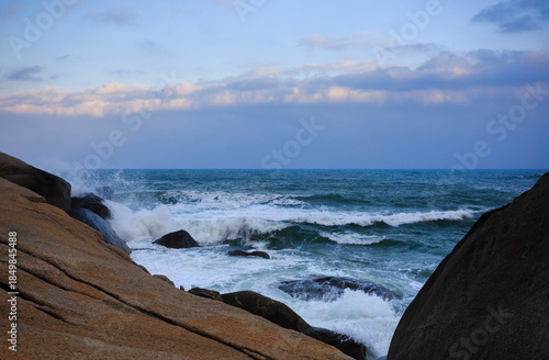 Two rocks form a huge V shape, and the emerald sea churns up velvety waves.