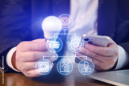 Person holds smartphone while looking at icons representing technology, files, and data analysis in an office setting during day