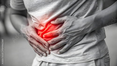 Person gripping stomach in apparent abdominal pain
