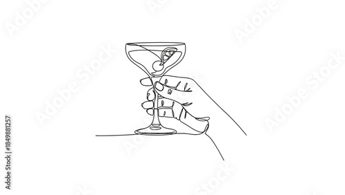 Hand holding elegant martini glass with olive and lemon twist
