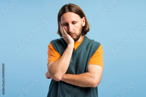 Φωτογραφία Unhappy man feeling bored, tired, or pensive, hand supporting his cheek