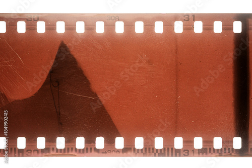 Dusty and grungy 35mm film texture or surface. Perforated scratched camera film isolated on white background.