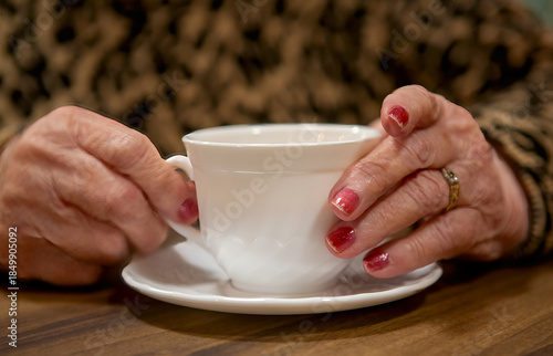 Older woman's hands holding a cup of tea
