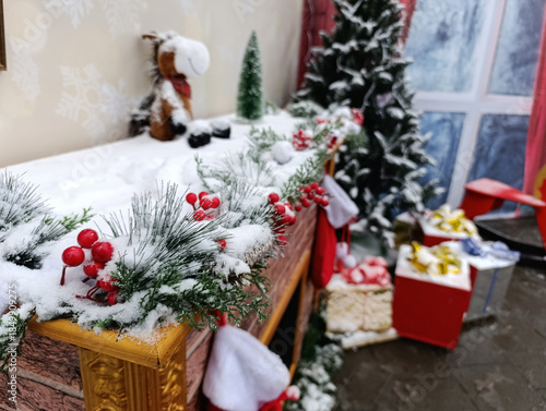 Christmas fireplace decor with garland, gifts and snowy winter interior