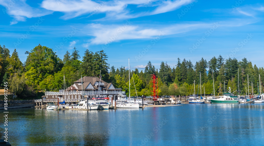 Obraz premium Stanley park seawall showcasing siwash rock, brockton point lighthouse and boats in vancouver, british columbia