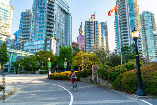 Fotografia Student cycling in downtown vancouver with canadian flags waving