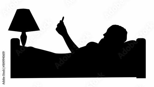 Man relaxing on couch with lamp, using phone in evening