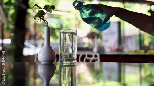 refreshing water being poured from bottle close up