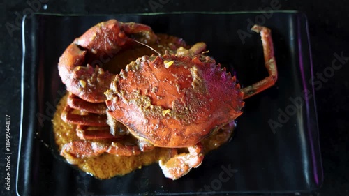 spicy crab curry served on black plate closeup