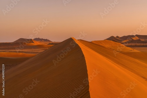 Dramatic Sunset Over Rolling Sand Dunes in Desert Landscape