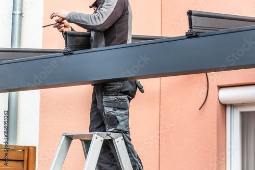 Workers install patio roofing with steel and glass
