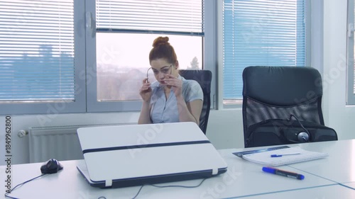 Young red-haired businesswoman working on a laptop in modern office conference room