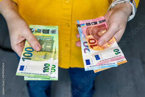 Εκτύπωση καμβά Person holding euro banknotes in both hands separating money into two stacks