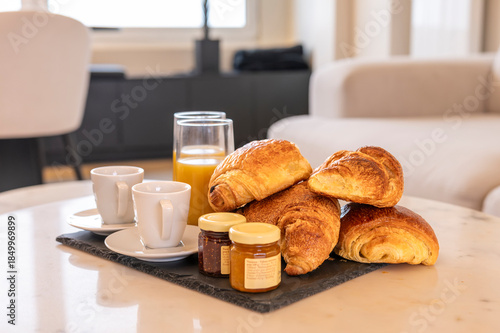 Plateau petit déjeuner avec croissants, café et jus d'orange
