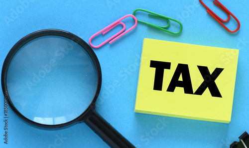 TAX word on a small yellow piece of paper. Tax Business Concept .