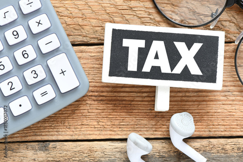 TAX words on a small chalkboard and wooden table.