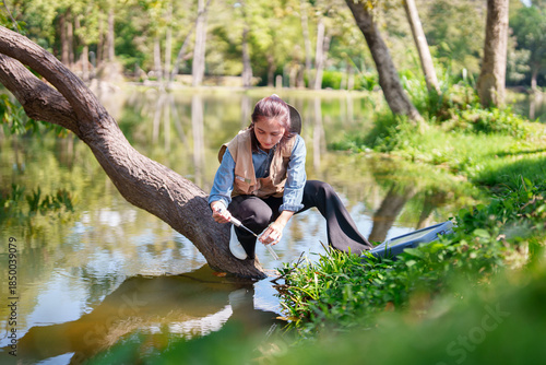 Asian botanist researcher collects water samples in natural environment conducting scientific fieldwork to study plants