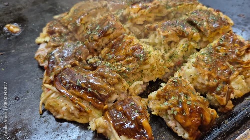 Hot freshly cook okonomiyaki Japanese style pizza on hot plate Osaka street food
