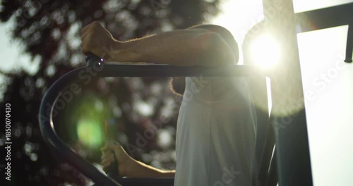 Young athlete performs abs exercise in sunset, street workout, slow motion, middle close up 