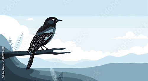 Beautiful black bird sits calmly on a tree branch with a scenic mountain range and soft clouds in the blue background.
