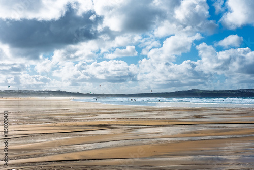 Surfing at Hayle Beach in Cornwall UK under a dramatic sky