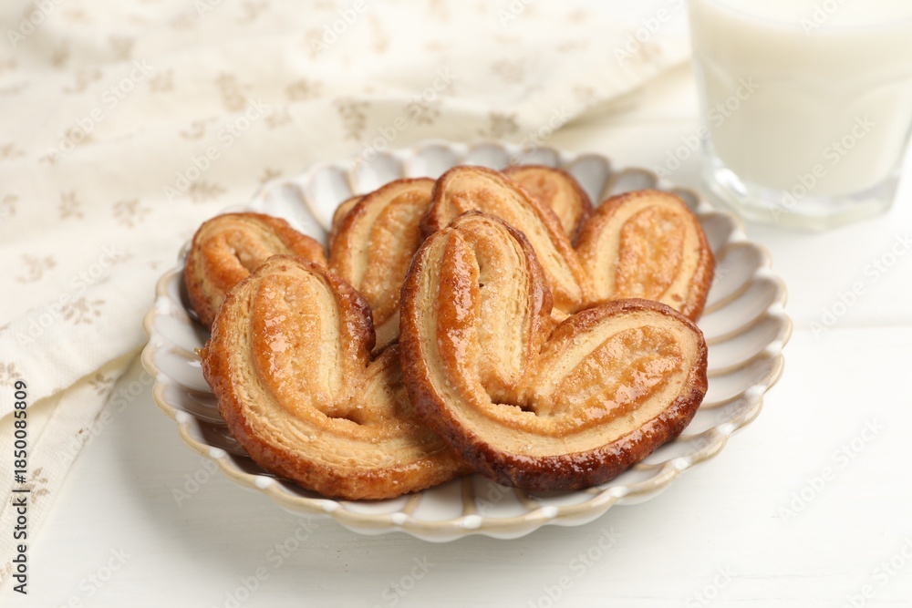 Fototapeta premium Yummy palmiers and milk on white wooden table, closeup