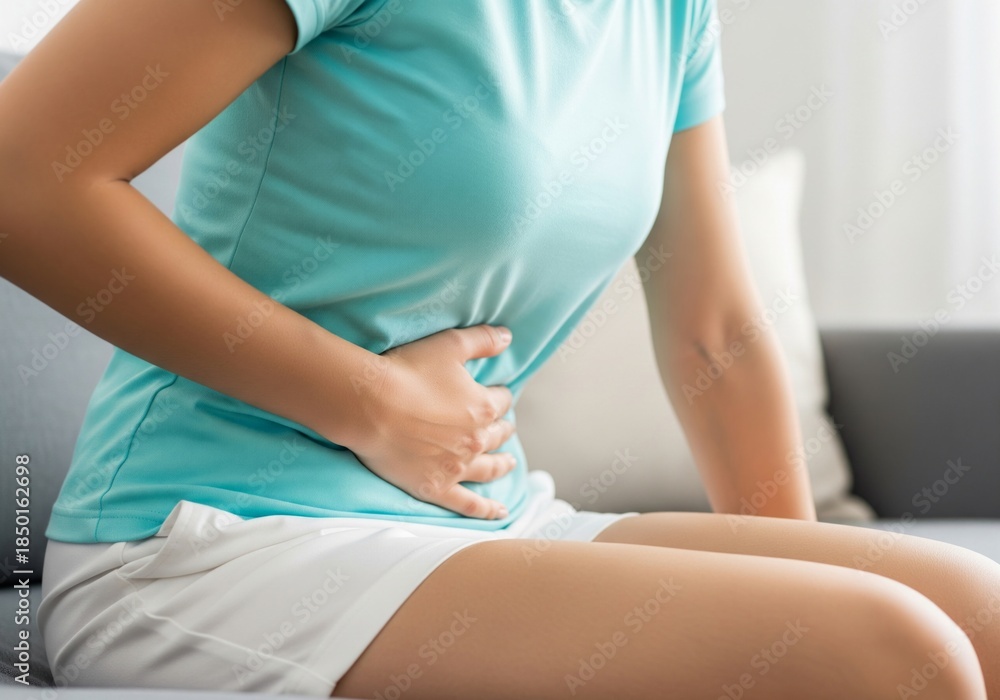 Obraz premium Woman Holding Stomach With Abdominal Pain at Home