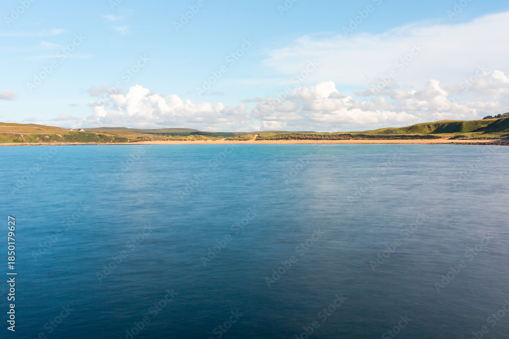 Fototapeta premium Melvich Bay. Scotland, NC500 route. Calm coastal landscape with blue sea, sandy shore, and wide open sky