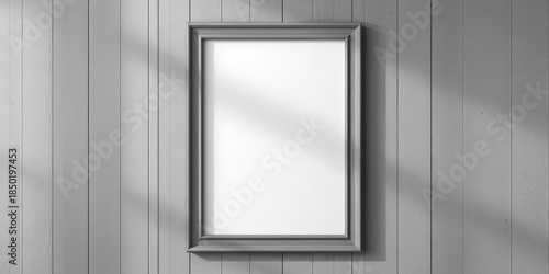 Grey wooden frame with empty white poster mounted on a grey painted wood wall, used for visual presentation or advertising