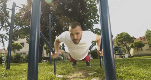 Young male fit athlete performing push up exercise, street workout concept, slow motion