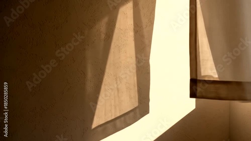 Sunlight streaming through a window, casting warm shadows on the wall and floor, creating a peaceful and serene atmosphere in a room.