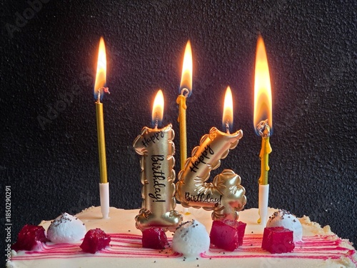 Birthday cake and candles in the dark, close-up. Birthday cake with a candle in the form of the number 14. Celebrating a birthday or landmark event. climax of celebration