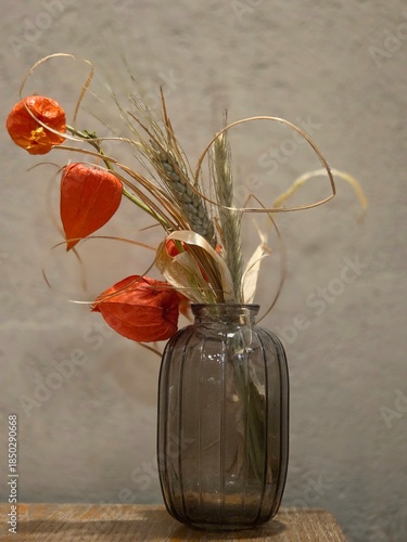 Bouquet in a glass vase on a wooden table. Beautiful botanical shot, natural wallpaper.