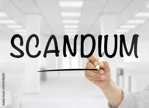 Wallpaper Mural A conceptual image featuring the word scandium handwritten in bold black letters on transparent glass, with a blurred white modern office interior in the background, symbolizing this rare metal’s role Torontodigital.ca