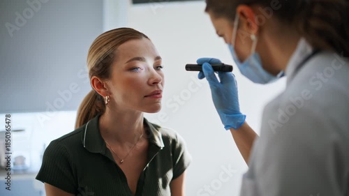 Neurologist testing woman eyes reflexes during checkup. Doctor checking health