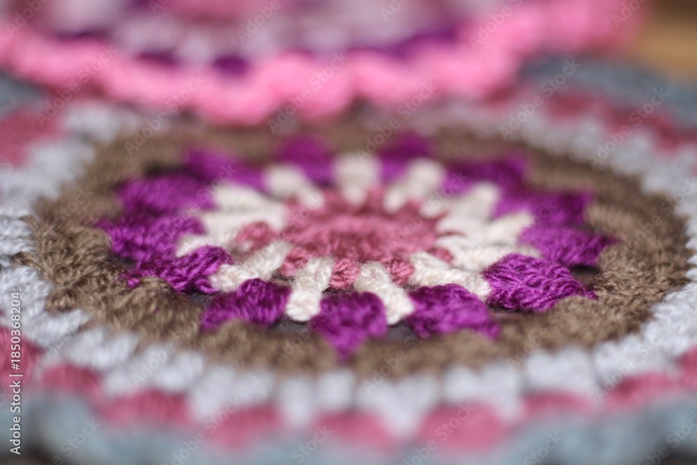 Fototapeta premium Crocheted mandala doily on wooden background handmade decor art craft photo 