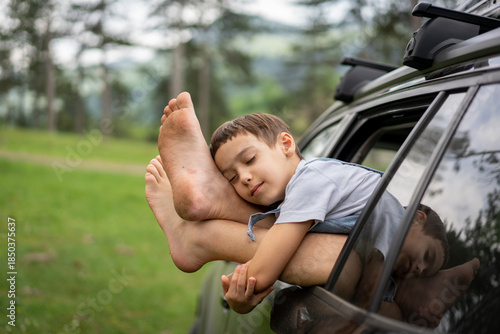 Content Child Resting Head on Car Window Frame in Nature. High quality photo