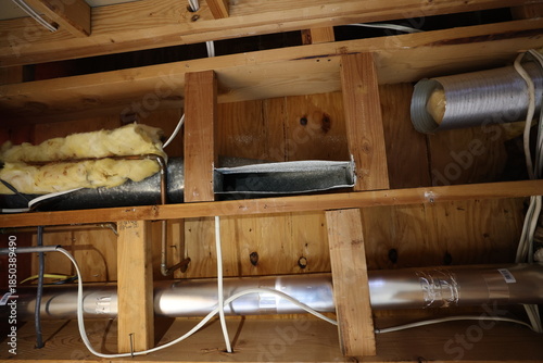 Look up at the underside of a floor in a home with pipes and insulation running under. This would normally be where the ceiling is. 
